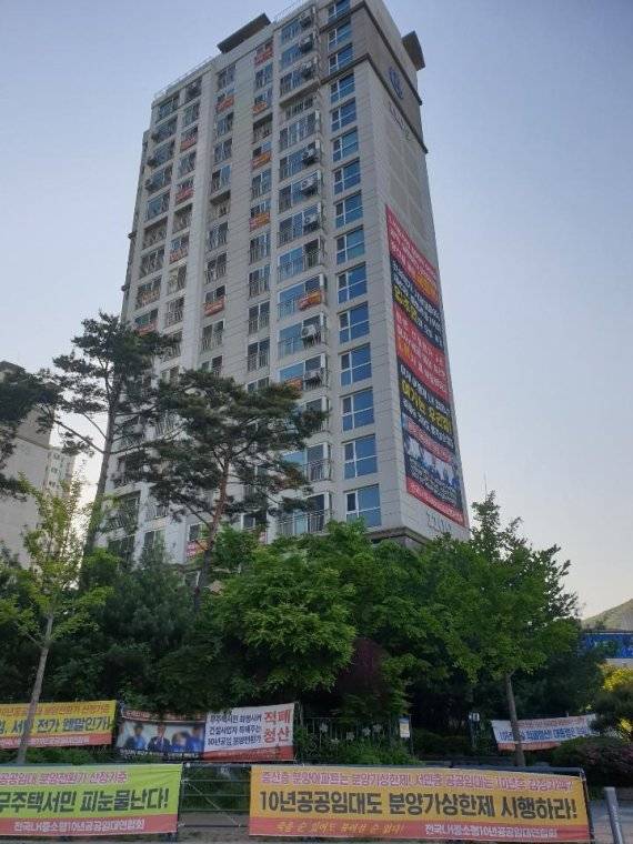 경기도 성남시청의 분양 전환 방식에 반대하는 입주민들이 판교 중소형 10년 공공임대아파트에 플래카드를 걸어 분양가 상한제 적용을 주장하고 있다.