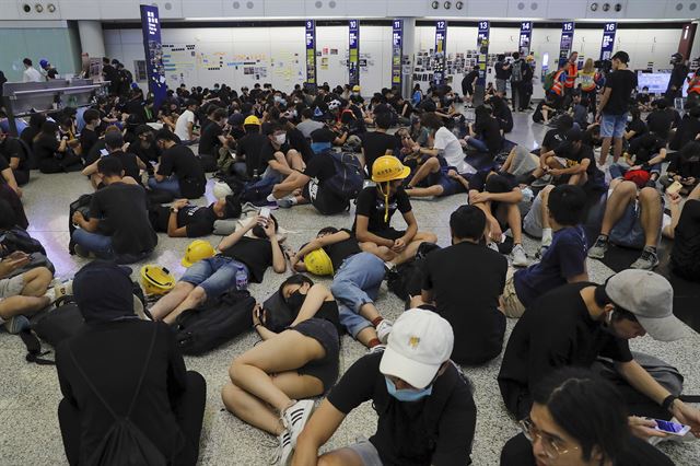 홍콩 시위대가 12일 공항 점거 시위를 벌이면서 공항이 마비되는 사태가 발생했다. 시위대는 13일에도 시위를 예고했다. 사진은 홍콩 시위대들이 12일 공항 점거하고 있는 모습. 홍콩=AP 연합뉴스