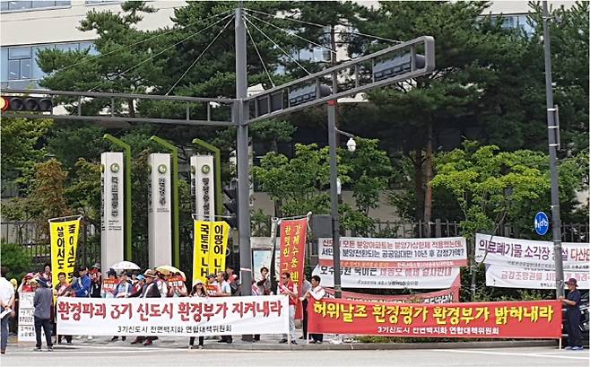 3기신도시전면백지화연합대책위원회가 23일 낮 정부세종청사 환경부 앞에서 전략환경영향평가 관련 문제를 지적하는 집회를 열고 있다. 사진=3기신도시전면백지화연합대책위원회