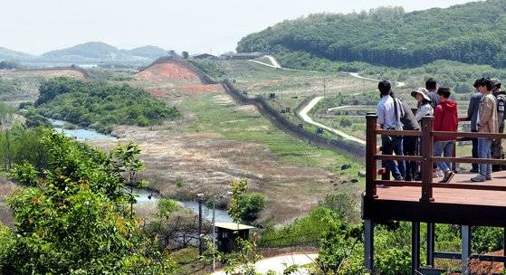 DMZ 평화의길 철원 구간, 공작새능선전망대에서 바라본 DMZ 풍광. 철책 너머로 사람 손길 닿지 않은 역곡천과 숲이 보인다. [중앙포토]