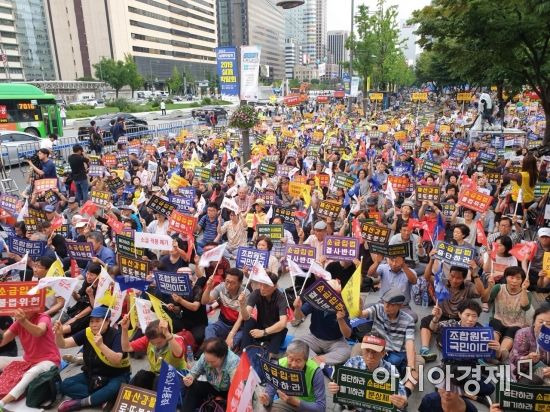 ▲ 9일 저녁 서울 종로구 세종로공원에서 열린 '분양가상한제 소급적용 저지 재개발·재건축 조합원 총궐기대회'에서 참석자들이 구호를 외치고 있다. (사진: 이춘희 기자)