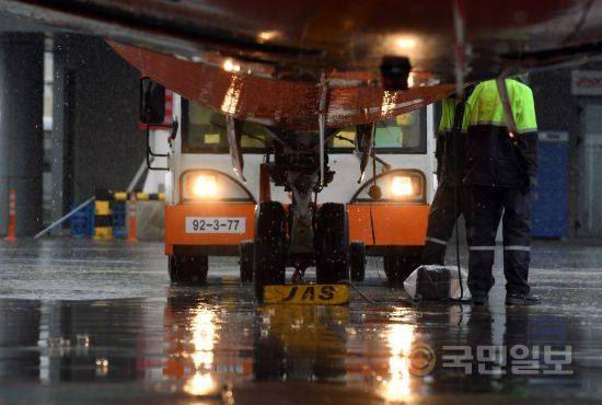 비 오는날 헤드라이트를 밝히는 토잉카. 이 토잉카를 이용해 계류장의 비행기를 활주로로 밀어낸다.