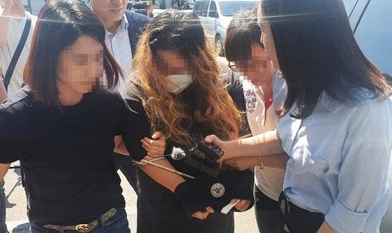 전북 익산의 한 원룸에서 함께 살던 20대 지적장애 여성을 야산에 암매장한 혐의를 받고 있는 여성이 지난 18일 법원에서 영장실질심사를 받고 군산경찰서로 들어가고 있다. [뉴스1]
