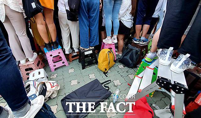 의자와 사다리에 올라 연예인을 카메라에 담는 모습.