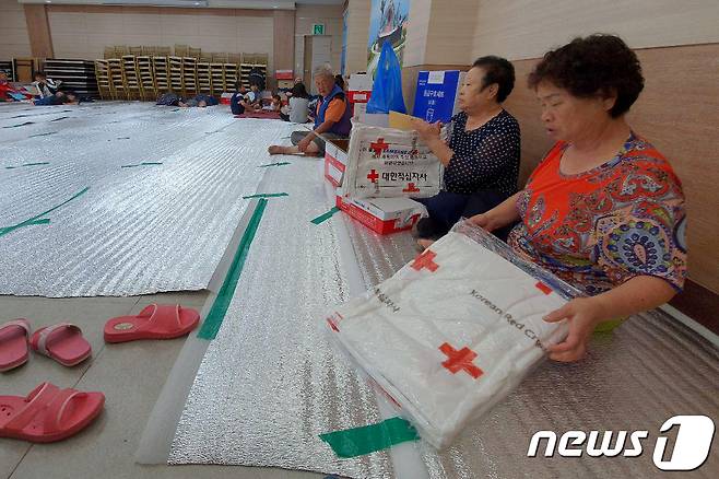 3일 오전 제18호 태풍 '미탁'의 영향으로 많은 비가 내린 강원도 삼척시에 마련된 한 대피소에서 이재민들이 대한적십자사의 구호물품을 받아보고 있다. 2019.10.3/뉴스1 © News1 서근영 기자