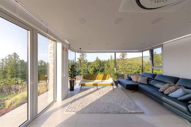 3면이 유리창으로 된 2층 거실에서 사시사철 변화하는 제주 오름의 다채로움을 잘 느낄 수 있다. ©포머티브건축사사무소