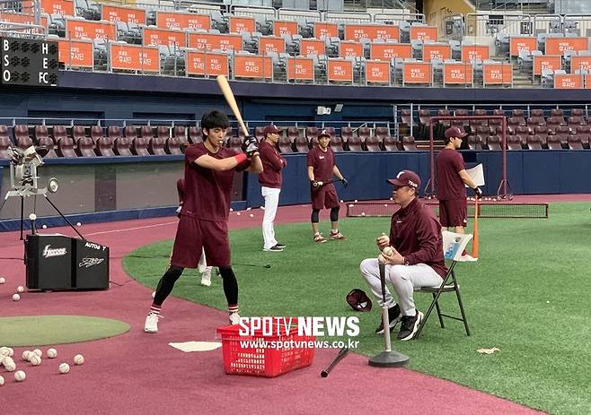 ▲ 20일 훈련 때 김규민(왼쪽)이 '웨하스'를 물고 강병식 코치와 함께 타격 훈련을 하고 있다. ⓒ고척돔, 고유라 기자