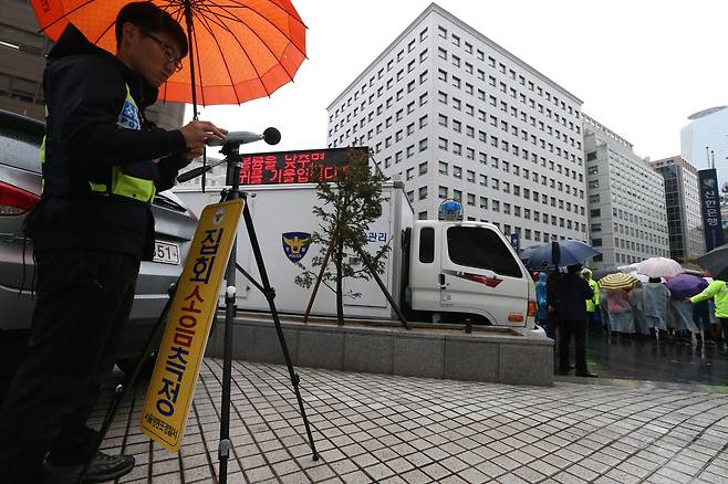 영등포 경찰서 집회 소음관리팀이 여의도 새누리당 앞에서 열린 집회에서 소음을 측정하고 있다. [중앙포토]