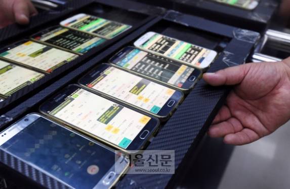 퀵서비스 기사의 휴대전화 - 한 퀵서비스 기사가 직접 제작한 휴대전화 거치대를 들고 물품을 배달하고 있다. 세상에 어느 하나 쉬운 일이 없다지만 이렇게 많은 휴대전화로 콜을 받을 거라는 생각은 못 했다. 가족을 위해 열심히 사는 모든 가장들에게 찬사를 보낸다.도준석 기자 pado@seoul.co.kr