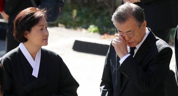 문재인 대통령이 31일 오전 부산 남천성당에서 모친 고 강한옥 여사의 운구행렬 중 눈물을 닦고 있다. 왼쪽은 김정숙 여사. 2019.10.31. 도준석 기자 pado@seoul.co.kr