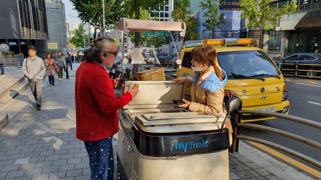 유동 판매(카트를 한 곳에 정차해놓고 유동 인구를 대상으로 하는 판매) 중 단골과 만나 이야기를 나누는 모습. 배달 신청은 하지 않았지만 매번 들리는 고객도 많다고 한다.