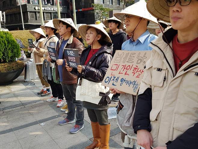 23일 서울 중구 파이낸스센터 앞에서 열린 ‘베트남 민간인 학살, 이제는 국가의 책임을 묻습니다’ 문화제 참가자들이 청와대를 향해 선 채 “우리는 진실을 원합니다”라고 외치고 있다. 베트남식 삿갓 ‘넌라’에 51년 전 학살당한 베트남전 민간인 학살 피해자들의 이름이 적혀있다.