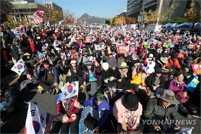 9일 오후 서울 광화문 교보빌딩 앞에서 문재인하야범국민투쟁본부 주최로 열린 대한민국 바로세우기 국민대회에서 참가자들이 구호를 외치며 태극기와 손팻말을 흔들고 있다. (사진제공=연합뉴스)