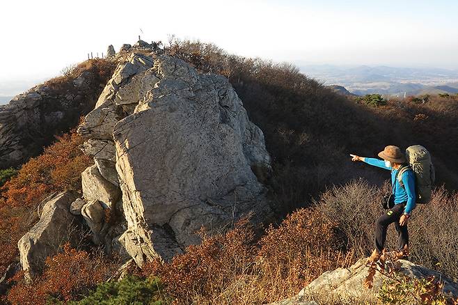 석문봉 남쪽 안부(문다라미)를 건너온 암봉에서 북쪽으로 뒤돌아 본 석문봉과 그 아래 수직 절벽인 사자(얼굴)바위.