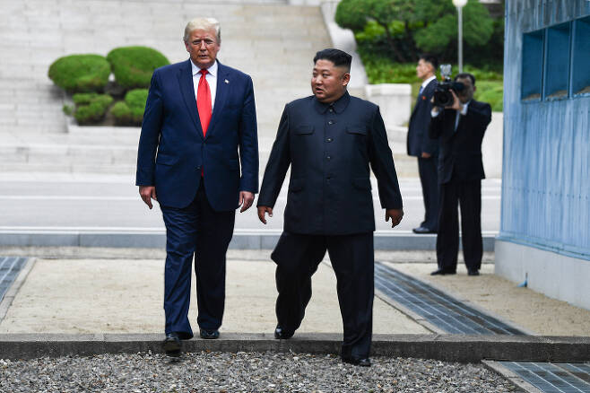 도널드 트럼프 미국 대통령과 김정은 북한 국무위원장이 6월 30일 판문점 군사분계점을 함께 넘고 있다.[사진=AFP제공]