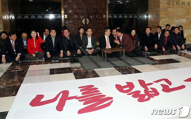 황교안 자유한국당 대표가 11일 저녁 서울 여의도 국회 로텐더홀 앞에서 무기한 농성에 들어가며 자유한국당 의원들과 자리를 펴고 앉았다. 황교안 대표는 농성에 들어가며 ‘패스트트랙 2대악법 철회’와,‘문정권 국정농단 3대 게이트 규탄’을 내 걸었다. 2019.12.11/뉴스1 © News1 이종덕 기자