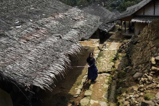 바두이족 마을의 가옥은 모두 내나무와 야자 껍질로 만들어진다. 한 여성이 집 주변을 돌고 있다. [EPA=연합뉴스]