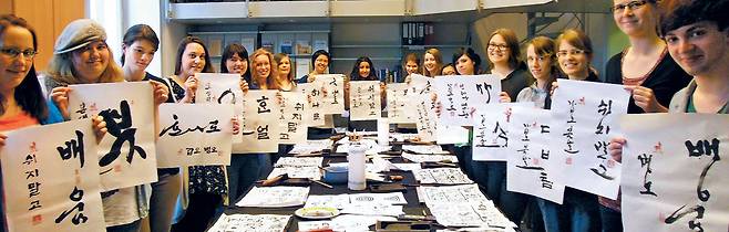 독일 세종학당 학생들 "제 한글 솜씨 어떤가요" - 독일 본에 있는 세종학당에서 한글 서예 강좌에 참여한 학생들이 직접 쓴 글씨를 들고 있다. 문화체육관광부 산하기관인 세종학당은 전 세계 60개국 180곳에서 한국어와 한국 문화를 가르치고 있다. /세종학당