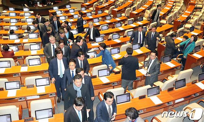 더불어민주당 의원들이 30일 서울 여의도 국회 본회의장에서 열린 제 374회 국회(임시회) 제1차 본회의에서 고위공직자범죄수사처 설치 및 운영에 관한 법률안(공수처법)이 표결로 의결된 후 인사를 나누며 본회의장을 나서고 있다. 자유한국당 의원들은 표결방법에 대한 무기명 투표 변경요구의 건이 부결되자 본회의장을 퇴장했다. 2019.12.30/뉴스1 © News1 이종덕 기자