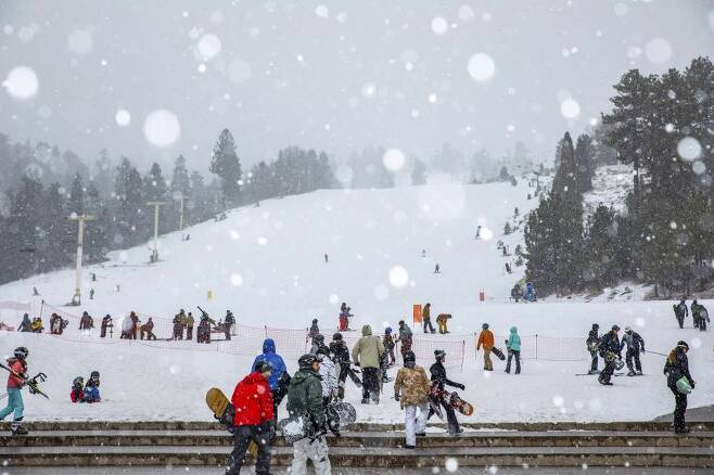 지난 12월23일(현지시간) 미 캘리포니아주 LA 근교 빅베어마운틴 리조트에 눈이 내리는 가운데 스노우보더들이 슬로프로 올라가고 있다. /사진=뉴시스