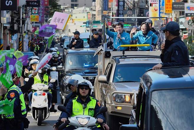 대만 총통 선거를 하루 앞둔 10일(현지시각) 여당 민진당의 후보인 차이잉원 총통(가운데 차량 오른쪽)이 신타이베이 반차오 거리에서 지지자들에게 손을 흔들며 마지막 유세를 하고 있다. 타이베이/AFP 연합뉴스