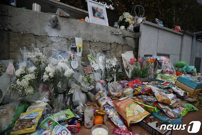 지난해 12월 31일 울산 울주군 한 아파트 앞 인도에서 교통사고로 숨진  두 살배기 남아를 추모하기 위해 시민들의 발길이 이어지고 있다.   임시추모소에 추모객들이 놓아 둔 조화와 인형, 과자 등이 쌓여 있다. 뉴스1 © News1 윤일지 기자