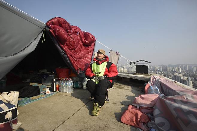 지난 2일 박문진씨가 옥탑 농성장에서 햇볕을 쬐고 있다. 70m 높이 옥탑에는 돌풍이 많이 불어 농성 텐트가 네댓번 무너졌다. 대구/강재훈 선임기자