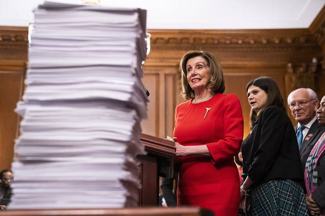 epa08082254 Democratic Speaker of the House Nancy Pelosi speaks to the media about the United States?Mexico?Canada Agreement (USMCA), along with other legislation, while standing next to a stack of bills she said were stalled in the Senate, in the US Capitol in Washington, DC, USA, 19 December 2019. Her press conference comes the day after the House of Representatives impeached US President Donald J. Trump on two articles: abuse of power and obstruction of Congress. EPA/JIM LO SCALZO 〈저작권자(c) 연합뉴스, 무단 전재-재배포 금지〉