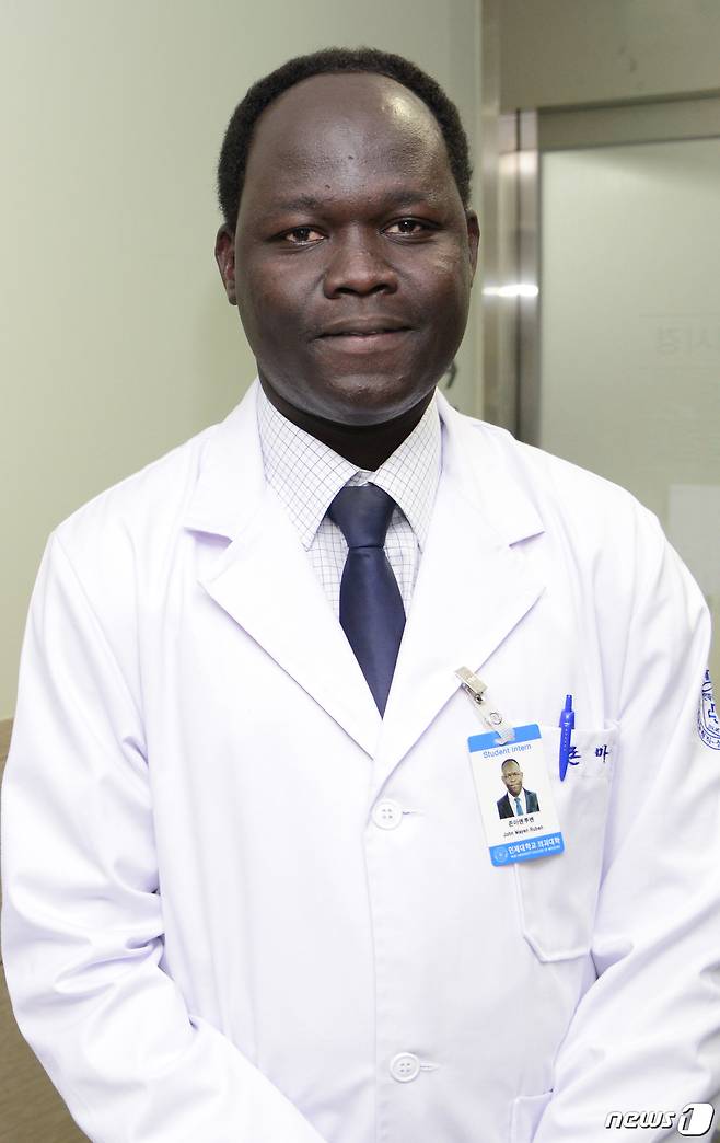 존 마옌 루벤(34)이 제84회 의사국가시험에 최종 합격해 의사가 될 자격을 얻었다. 존이 흰색 가운을 입고있다.(인제대학교 제공)© 뉴스1