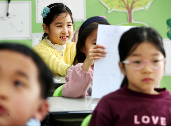 지난해 12월 22일 서울 용산구 용암초등학교에서 첫 겨울방학을 맞은 초등학교 1학년 학생들이 방학생활 계획표를 들어 보며 즐겁게 웃고 있다. [한주형 기자]