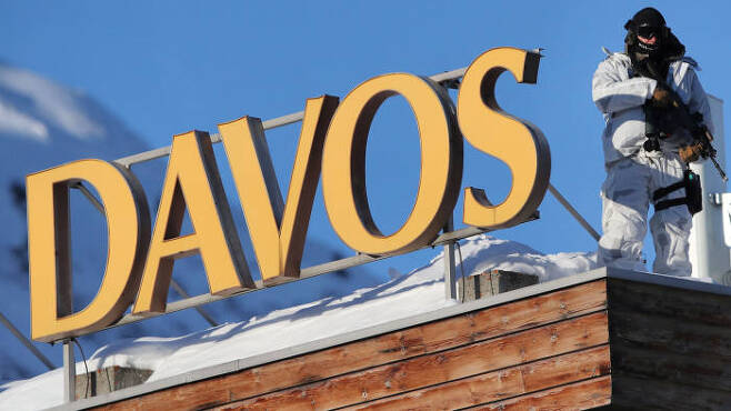 총기로 무장한 한 경찰이 21일(현지시간) 개막한 세계 경제포럼이 열리는 스위스 다보스의 한 건물 위에서 쥐위를 살펴보고 있다. 다보스 로이터 연합뉴스