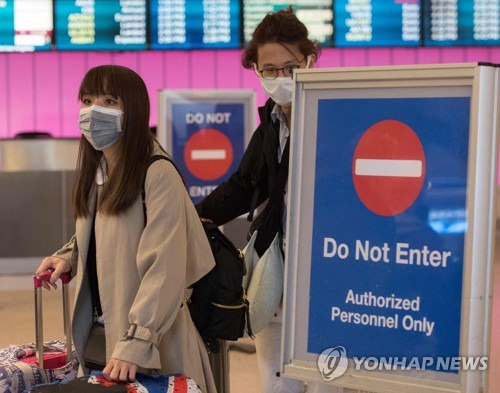 마스크를 쓴 채 로스앤젤레스 공항에 도착한 승객들 [AFP=연합뉴스]