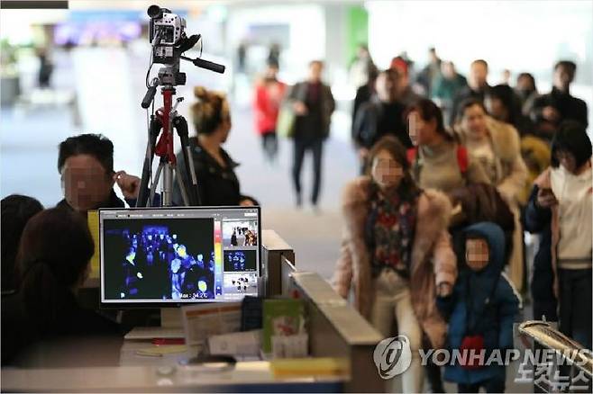 21일 오전 인천국제공항 1터미널 입국장에서 질병관리본부 국립검역소 직원들이 열화상 카메라로 승객들의 체온을 측정하고 있다. (사진=연합뉴스)