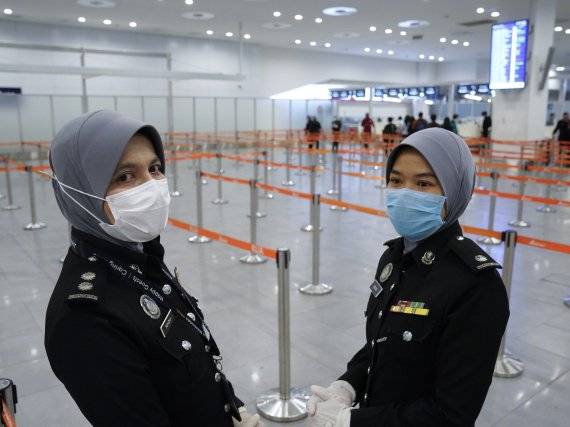 Immigration officials wear face mask at Kuala Lumpur Low Cost Terminal in Sepang, Malaysia, Wednesday, Jan. 29, 2020. Malaysia has tightened control at its borders and banned travelers from China's Hubei province as virus cases in the country rose to 7. (AP Photo/Vincent Thian) /뉴시스/AP /사진=