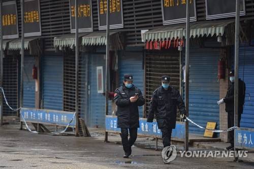 중국 우한 수산물 시장 순찰하는 안전요원들 (우한 AFP=연합뉴스) '우한 폐렴'의 진원지인 중국 후베이성 우한시에서 24일 안전요원들이 수산물 도매시장 주위를 순찰하고 있다. ymarshal@yna.co.kr