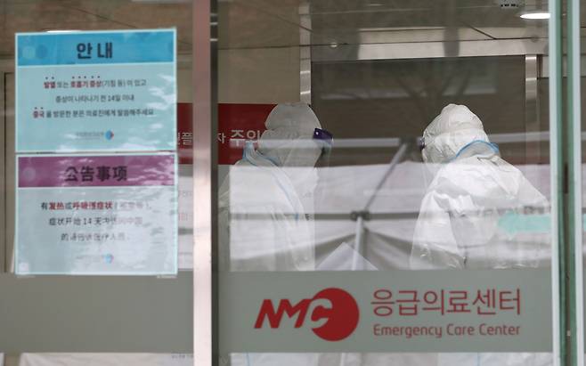 Medical staff at the National Medical Center in Seoul are photographed in full-body protective suits on Jan. 28. (Yonhap)　