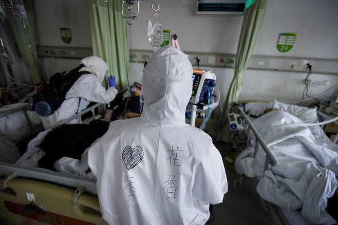 중국 의료진이 보호복을 입은 채로 6일(현지시간) 후베이성 우한의 신종 코로나 격리치료병동에 입원한 환자들의 상태를 살펴보고 있다.  우한 | 로이터연합뉴스