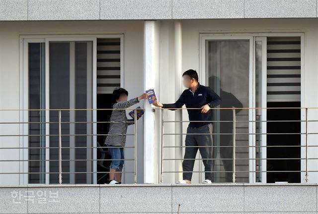 중국 후베이성 우한시에서 지난달 31일 전세기로 귀국해 임시 생활시설인 충북 진천군 국가공무원인재개발원에서 격리 생활을 하고 있는 교민들이 9일 오후 발코니 분리대를 사이에 두고 과자를 건네고 있다. 이날로 격리 열흘째를 맞는 우한 교민들은 초기에는 탈출했다는 점에 안도했지만, 격리 해제가 다가오면서 퇴소 이후 불확실한 미래에 대해 불안해 하고 있는 것으로 전해졌다. 진천=고영권 기자
