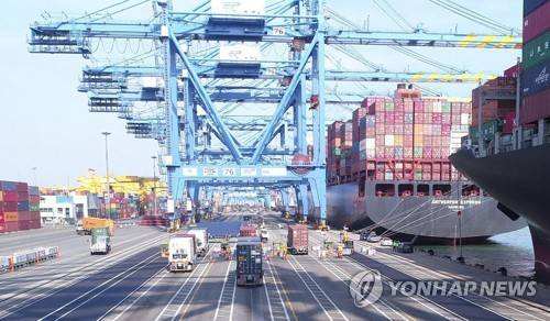 크레인과 멀리 떨어진 신항 2부두의 피닝스테이션 [PNC 제공]