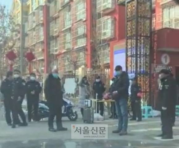 아파트 앞에서 주민들 발열 검사하는 중국 아파트 경비원들  - 중국 베이징의 아파트 입구를 지키고 있는 10여명의 경비원 모습. 이들은 수만 명에 이르는 아파트 주민들의 출입증과 체온을 매일매일 검사한다. 출입증이 없거나 외지인은 자가격리 14일을 거치지 않는 한 출입이 금지되며 발열이 감지되면 의심환자 보호시설(격리시설)로 바로 보낸다.  중국 현지 독자 제공