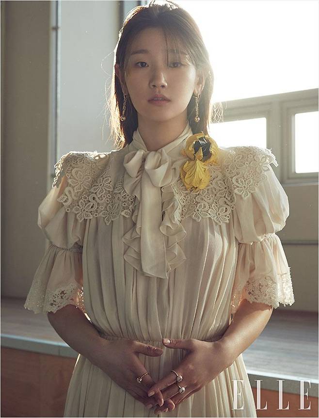 레이스와 셔링 장식의 드레스, B 블라썸 파인 주얼리 링과 이어링은 모두 Louis Vuitton.