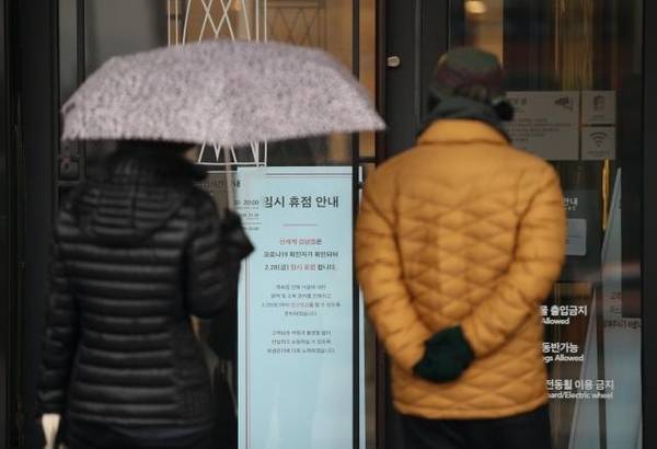 28일 신세계백화점 강남점 앞에 붙은 임시 휴점 안내문을 시민들이 보고 있다. /연합뉴스