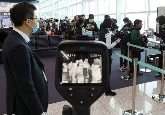 28일 오후 인천국제공항 2터미널 인천발 로스앤젤레스(LA)행 KE017편 탑승구 앞에서 대한항공 직원들이 탑승 승객의 발열 여부를 확인하고 있다. [연합뉴스]