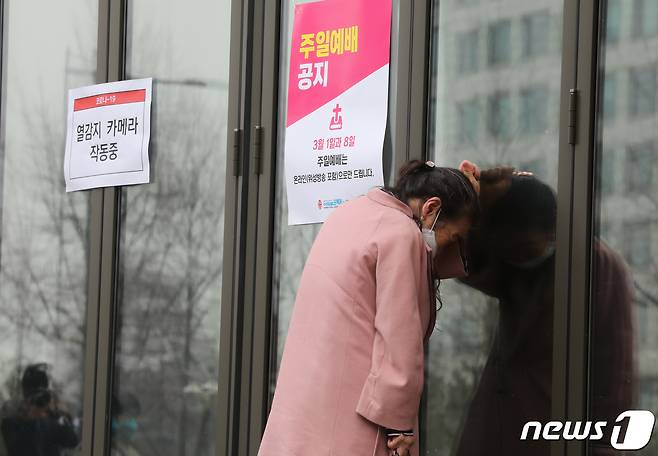 신종 코로나바이러스 감염증(코로나19) 확산을 막기 위해 정부의 당분간 실내외에서 종교집회 자제 호소에 여의도순복음교회가 주일예배를 포함한 모든 예배를 온라인예배로 대체한다고 밝힌 가운데 1일 오전 서울 여의도순복음교회를 찾은 한 신도가 예배당에 들어가지 못하자 유리문 앞에서 슬퍼하고 있다. 여의도순복음교회는 등록신도가 56만여명으로 추산되는 개신교계 초대형교회다. 2020.3.1/뉴스1 © News1 박정호 기자