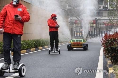 로봇 동원한 중국 우한의 방역 활동 (우한 AFP=연합뉴스) 신종 코로나바이러스 감염증(코로나19) 발원지인 중국 우한의 한 주거지역에서 3일 의용 방역대원들이 로봇을 조종해 소독제를 살포하고 있다.   jsmoon@yna.co.kr