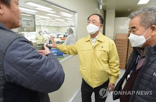 홍남기 부총리, 마스크 생산 현장 방문 (서울=연합뉴스) 홍남기 경제부총리 겸 기획재정부 장관이 9일 오후 경기도 안성 마스크생산 업체인 (주)케이엠을 방문해 생산 현장을 시찰하며 관계자로부터 설명을 듣고 있다. 2020.3.9       [기획재정부 제공. 재판매 및 DB 금지] photo@yna.co.kr