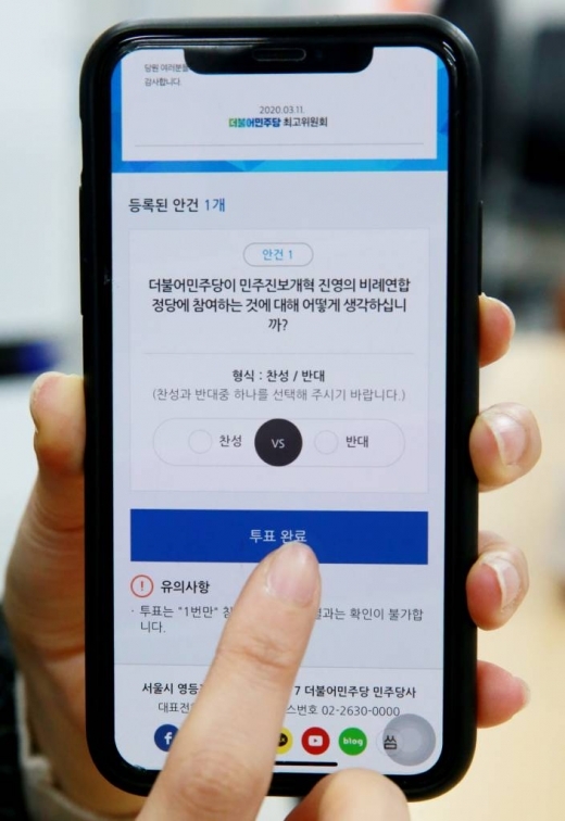 더불어민주당의 비례연합 참여 여부에 대한 온라인 투표가 실시된 12일 오전 서울 여의도 국회에서 한 민주당 권리당원이 스마트폰으로 온라인 투표를 하고 있다.
