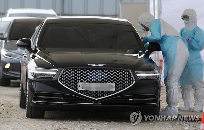 드라이브 스루 선별진료소 (서울=연합뉴스) 서명곤 기자 = 12일 오후 서울 강서구 이대 서울병원 코로나19 드라이브 스루 선별진료소에서 의료진이 검사를 하고 있다.   2020.3.12 seephoto@yna.co.kr
