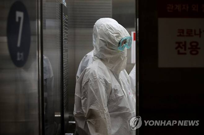 '오늘도 힘내자' (서울=연합뉴스) 신종 코로나바이러스 감염증(코로나19) 전담병원으로 지정된 서울 중랑구 서울의료원 상황실에서 방호복을 입은 의료진이 승강기에 올라 음압병실로 이동하고 있다. 2020.3.9 hwayoung7@yna.co.kr