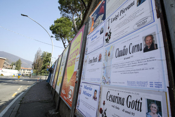 17일(현지시각) 이탈리아 롬바르디아주 베르가모 시내의 광고 게시판에 부고를 알리는 인쇄물이 붙어있다. AP 연합뉴스